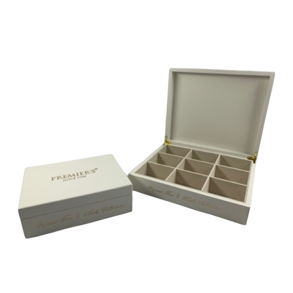 Two white rectangular boxes, one closed and one open. The open box has six compartments inside and both boxes have gold writing on the lid and side. The background is white.