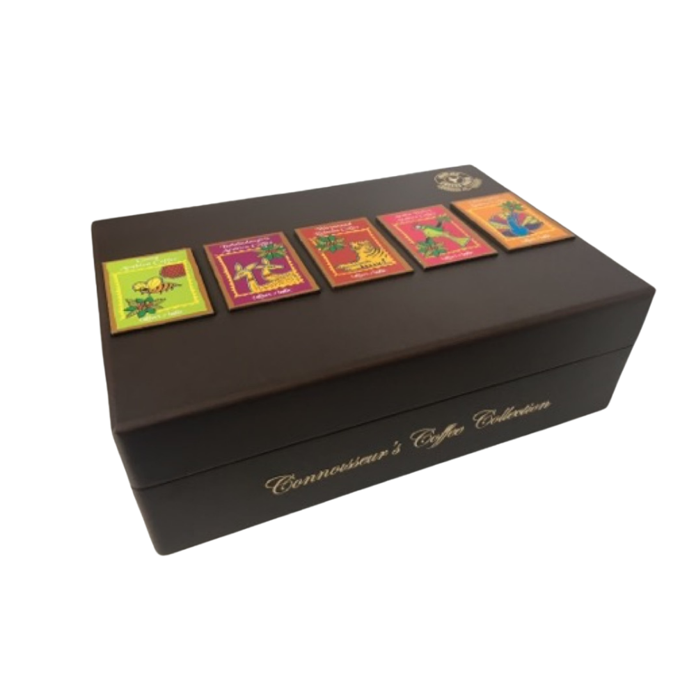 A dark brown rectangular box labeled Connoisseur’s Coffee Collection with five colorful coffee labels displayed on the lid, photographed against a white background.